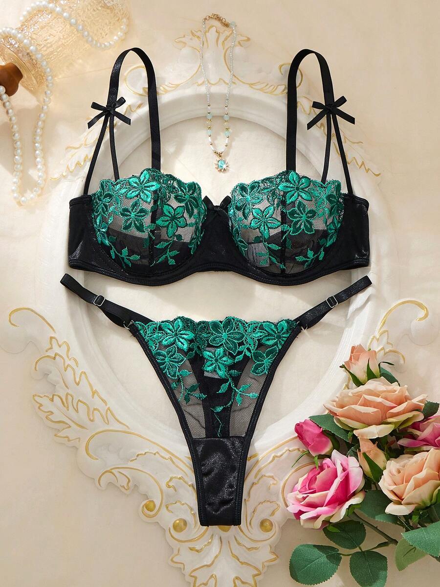 Conjunto de lencería negro con bordado floral verde esmeralda.