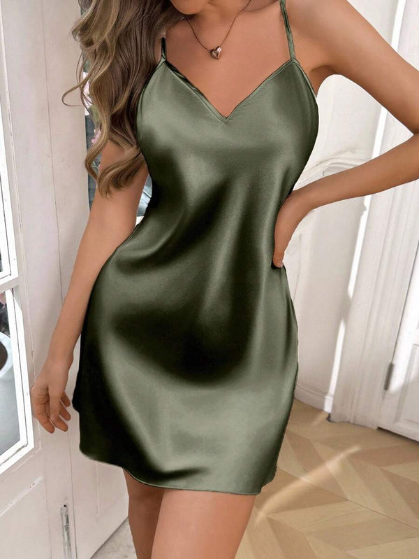 Perfil de una modelo luciendo un vestido lencero verde olivo con tirantes finos.