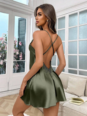Vista de espalda de un vestido lencero satinado color verde olivo con tirantes cruzados y detalle de encaje.