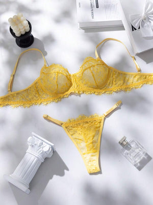 Conjunto de lencería de encaje amarillo en vista completa sobre un fondo blanco.