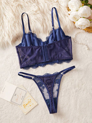 Detalle del bustier de encaje azul marino con tirantes ajustables y copas bordadas.