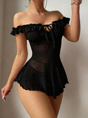 Primer plano de la falda con vuelo de un babydoll negro, mostrando la tela de malla transparente y el dobladillo ondulado.