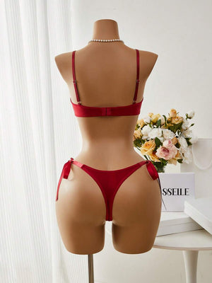 Detalle del sujetador de encaje floral rojo con tirantes ajustables y borde festoneado.