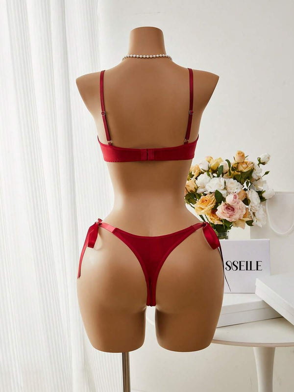 Detalle del sujetador de encaje floral rojo con tirantes ajustables y borde festoneado.