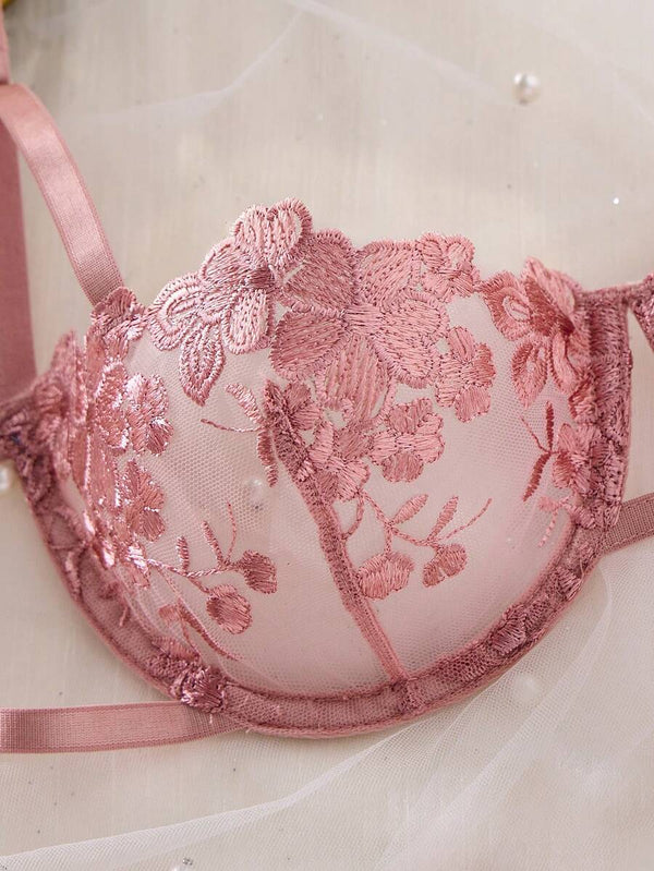 Vista cercana del bordado floral en conjunto de lencería romántica color rosa