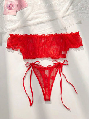 Detalle del top de lencería rojo estilo off-shoulder con volantes de malla.