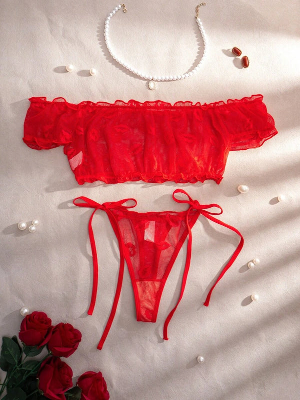 Tanga de lencería roja de malla transparente con lazos ajustables a los lados.