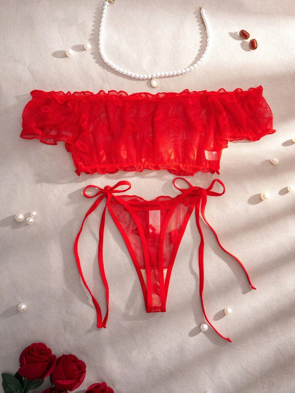 Vista frontal de la tanga de lencería roja con diseño de lazos laterales.