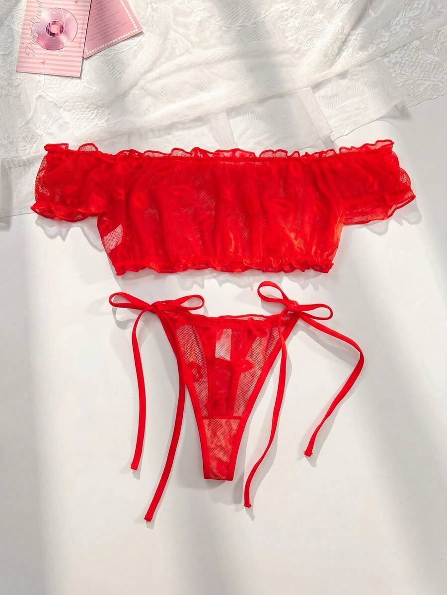 Conjunto de lencería rojo de dos piezas sobre una superficie blanca.