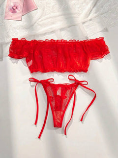 Conjunto de lencería rojo de dos piezas sobre una superficie blanca.
