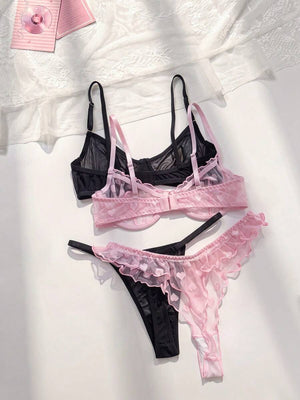 Detalle del sujetador de lencería rosa con estampado de corazones y volantes junto a un sujetador negro de malla.