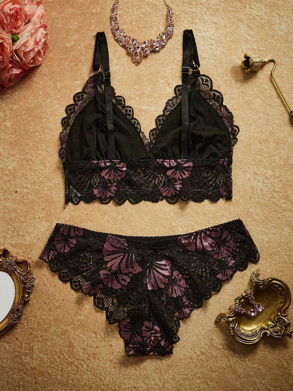 Detalle del bralette de encaje floral negro y lila con tirantes ajustables y bordes festoneados.