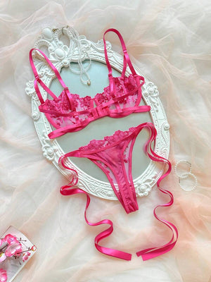 Detalle del sujetador balconette de lencería rosa con bordado de flores y tirantes ajustables.