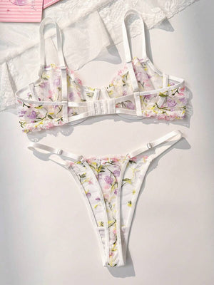 Detalle del bra de lencería con bordado floral en tonos púrpuras, rosas y amarillos.