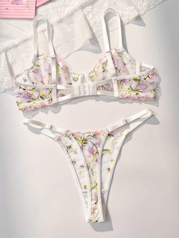 Detalle del bra de lencería con bordado floral en tonos púrpuras, rosas y amarillos.