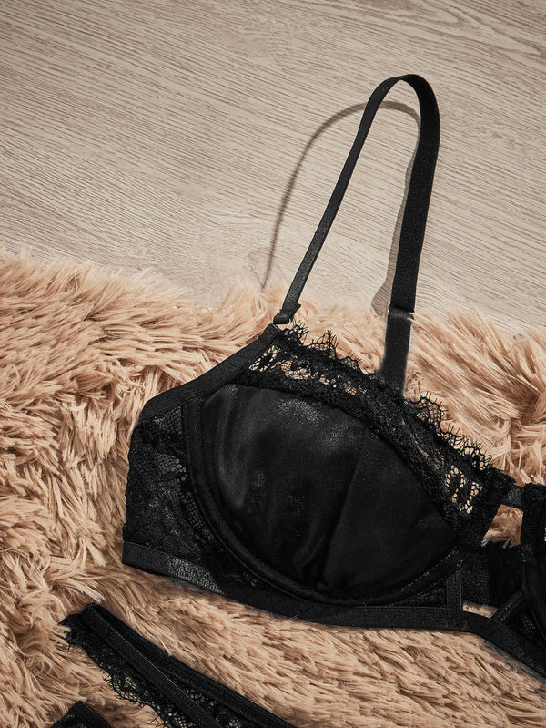 Panty tipo tanga negra de satín con tiras cruzadas de encaje en la cintura