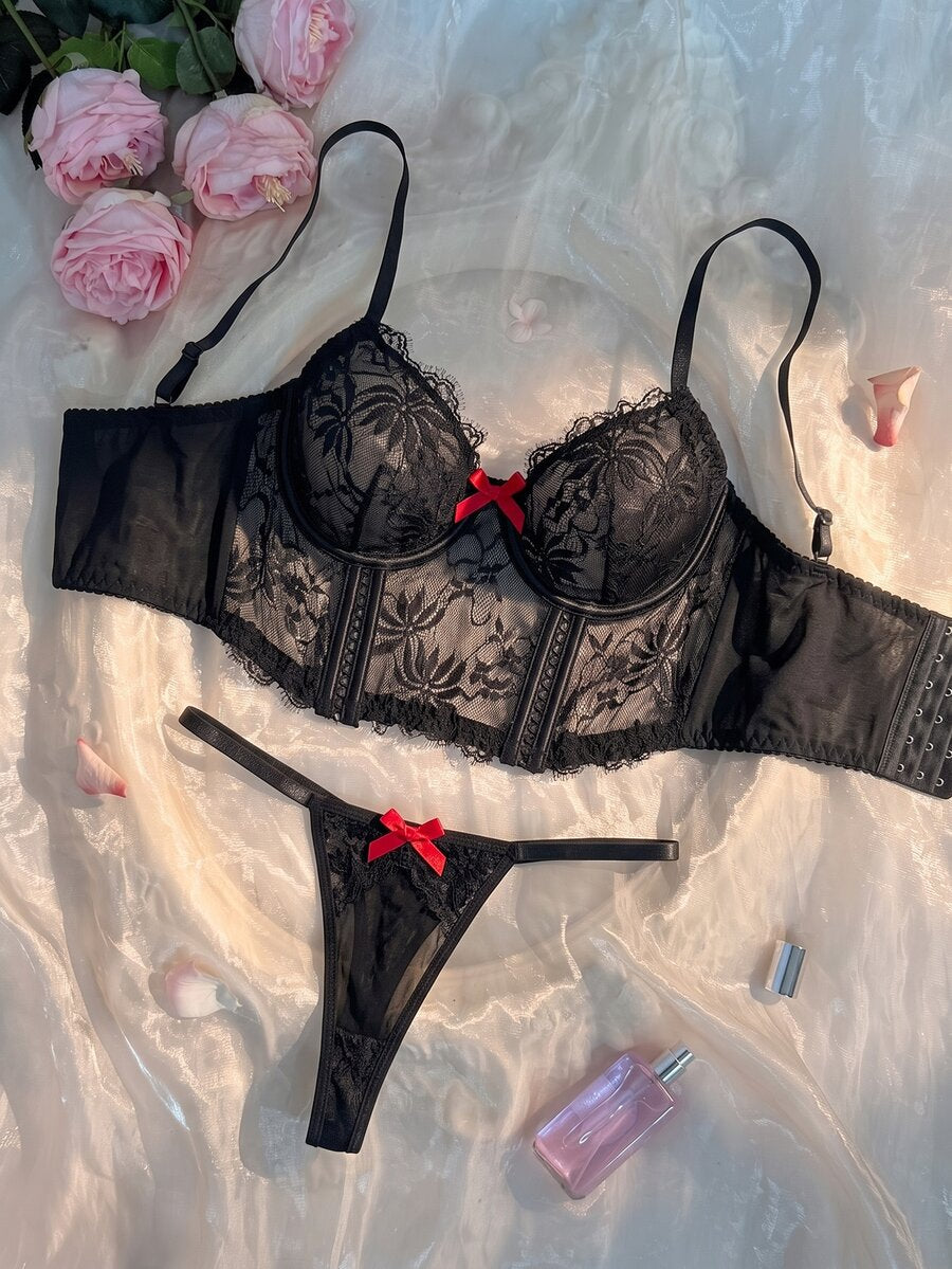 Conjunto de lencería de encaje floral negro con moños rojos vista frontal