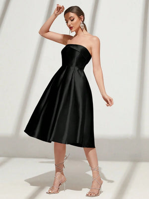Una modelo posando de lado con un elegante vestido negro midi sin mangas, ideal para eventos formales.