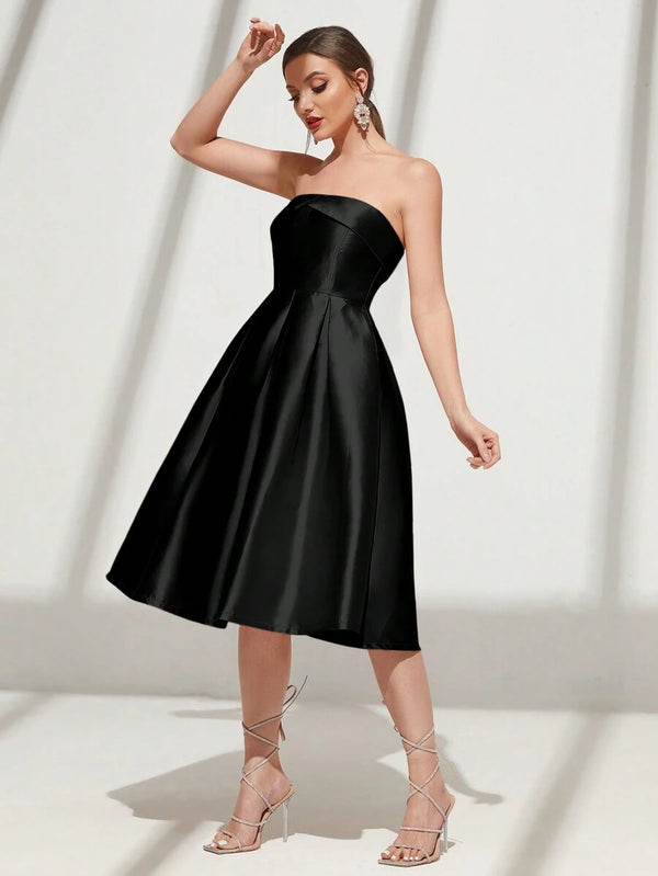 Una modelo posando de lado con un elegante vestido negro midi sin mangas, ideal para eventos formales.