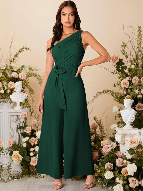 Modelo con mono largo verde oscuro elegante con cuello asimétrico y cinturón.