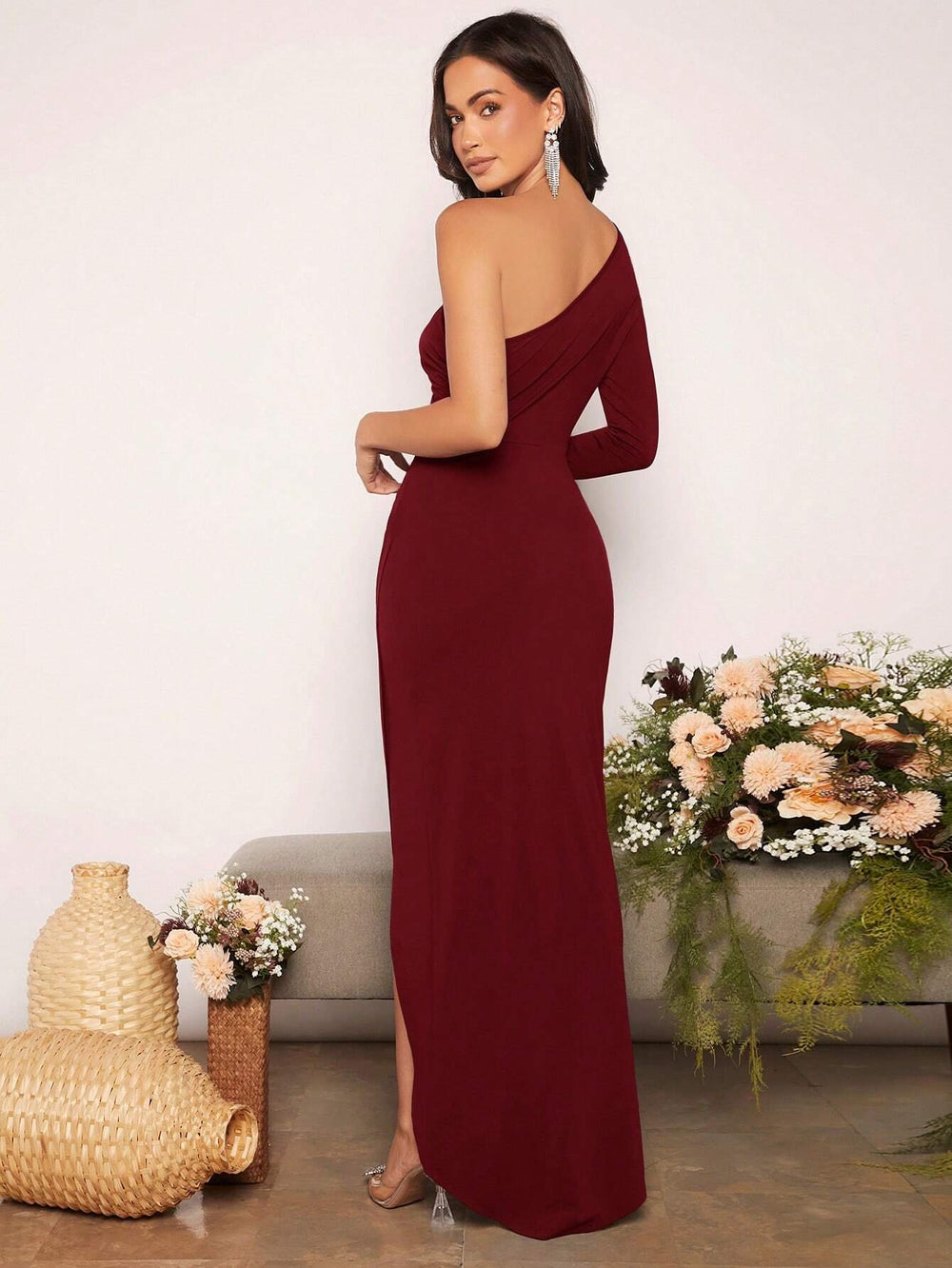 Vestido maxi granate con escote asimétrico y diseño envolvente.