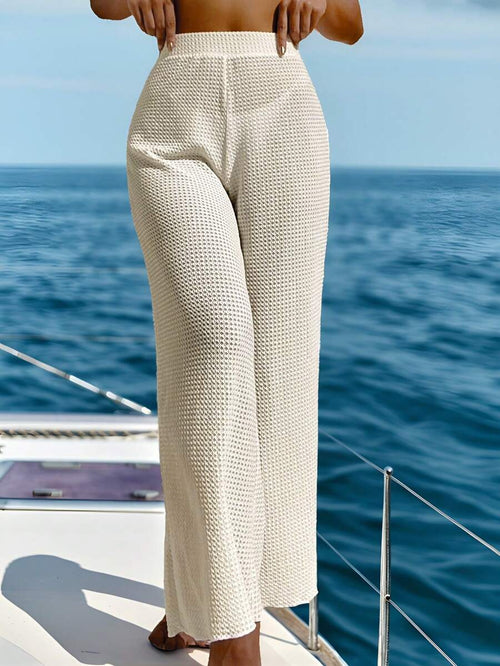 Vista frontal de pantalón ancho de tejido blanco crudo en una mujer en un yate.