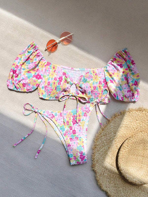 Detalle de la braguita de bikini floral con tejido fruncido y lazos ajustables en la cadera.