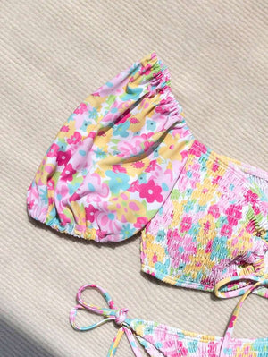 Primer plano del estampado floral vibrante y la textura fruncida del conjunto de bikini de dos piezas.