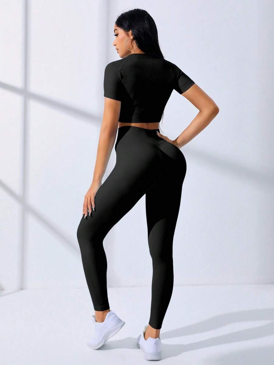 Mujer usando set deportivo negro sin costuras con top crop y leggings (set deportivo negro)