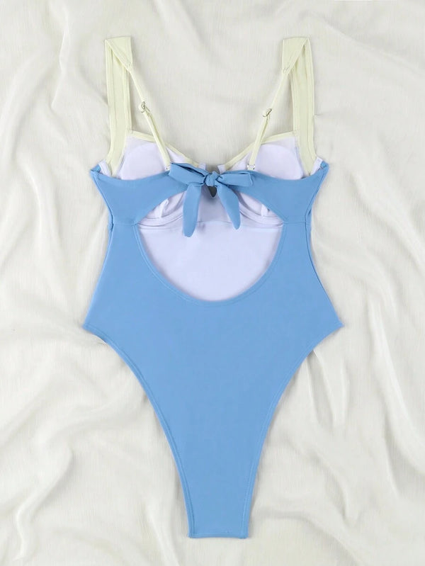 Detalle del escote en V profundo y las copas estructuradas de un traje de baño bicolor.