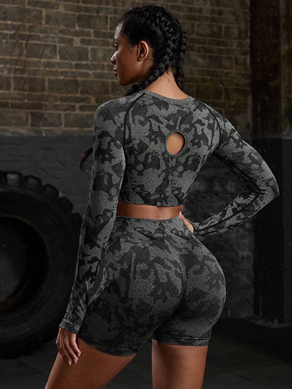 Imagen frontal del conjunto deportivo camuflaje negro, resaltando su ajuste y diseño sin costuras.