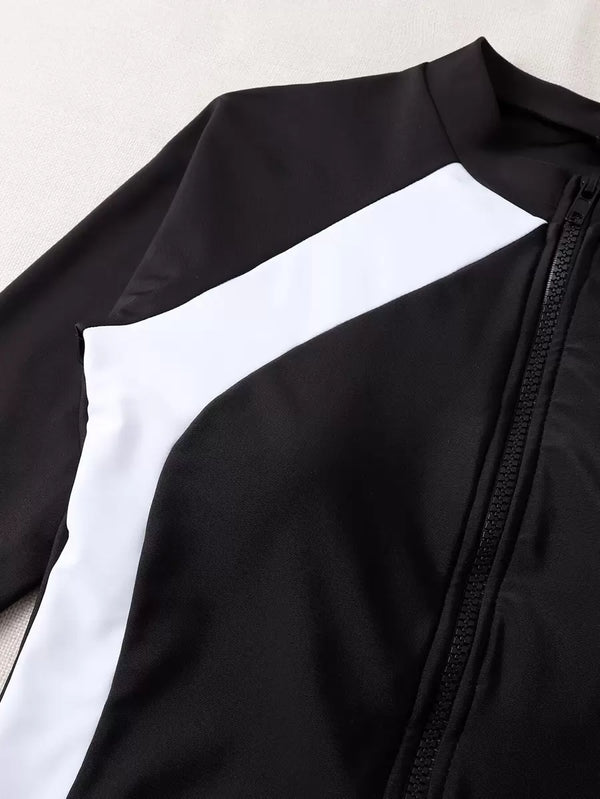 Silueta de un traje de baño enterizo que moldea la figura con bloques de color blanco y negro.