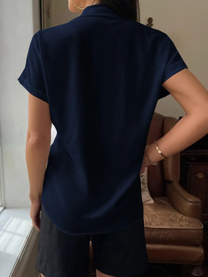 Vista trasera de la camisa azul marino, mostrando su corte redondeado.