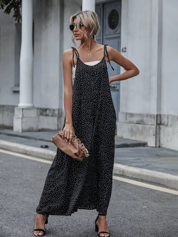 Detalle de la parte inferior de un jumpsuit de pierna ancha con estampado de lunares y sandalias de tacón negras.