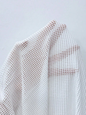 Vestido Playero Blanco Ajustado Con Escote En V Profundo en la playa.