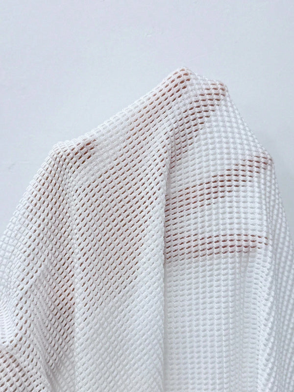 Vestido Playero Blanco Ajustado Con Escote En V Profundo en la playa.