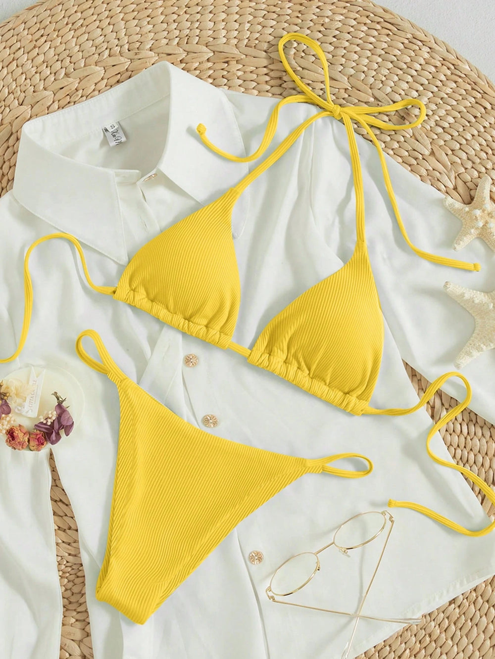 Imagen 1: Conjunto completo del Bikini Amarillo De Triángulo sobre una camisa blanca y accesorios de playa.