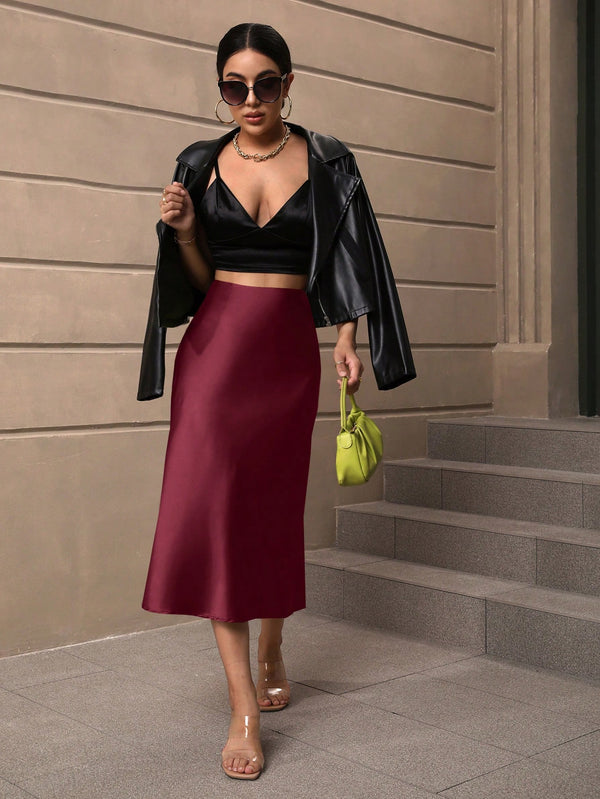 Detalle de caída en falda midi burdeos elegante.