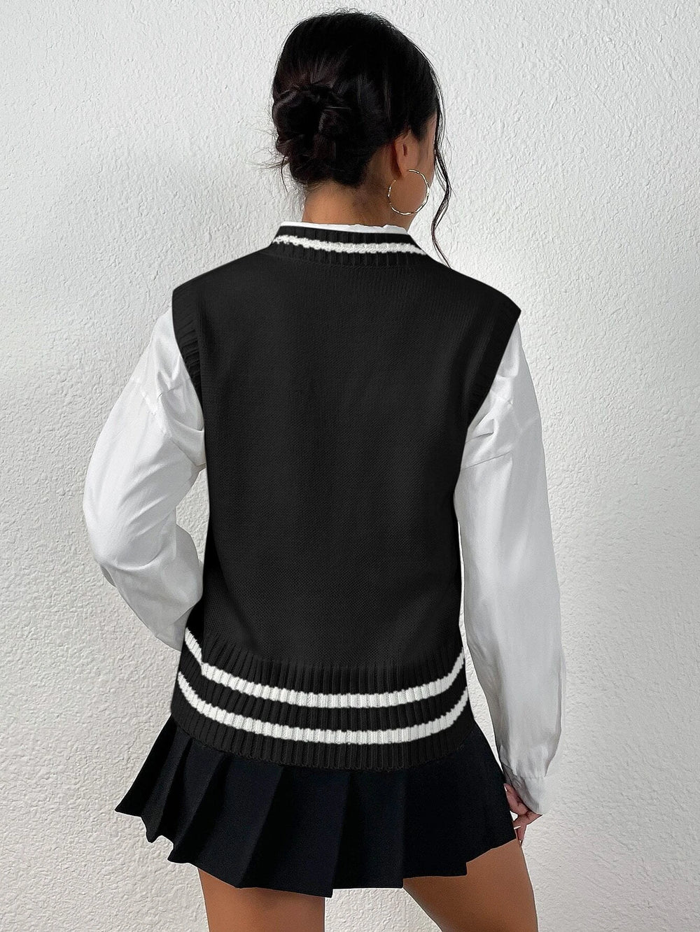 Suéter trenzado negro con ribete blanco, escote en "V" (Imagen 1).