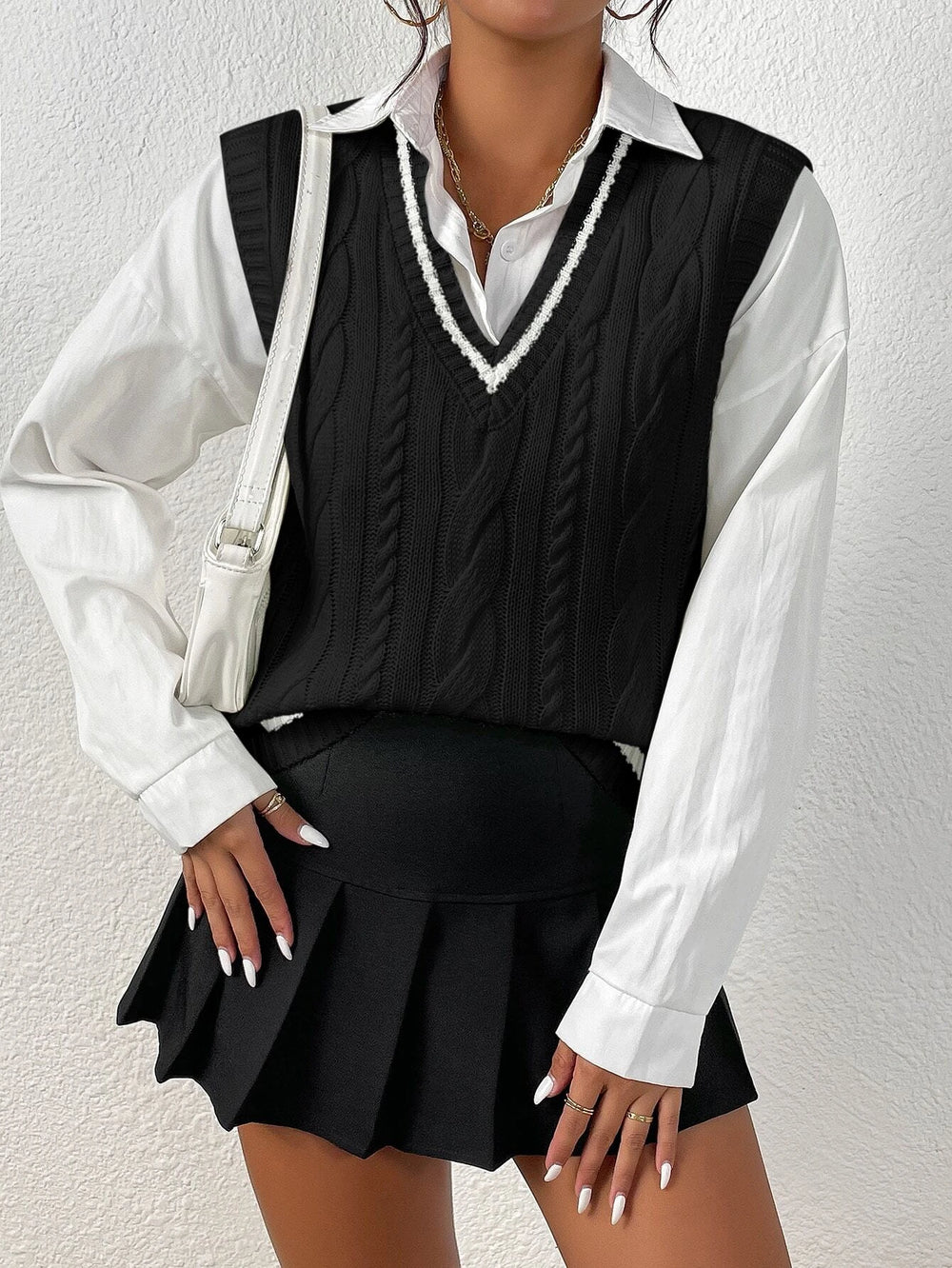 Suéter trenzado negro con ribete blanco, escote en "V" (Imagen 1).