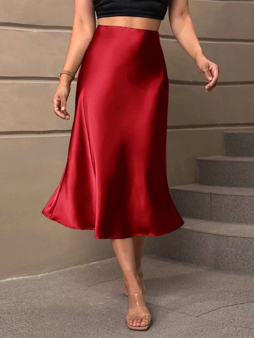 Falda midi roja satinada de talle alto con corte campana.