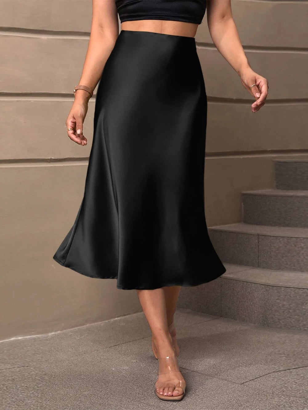 Falda midi negra satinada de talle alto con corte campana.