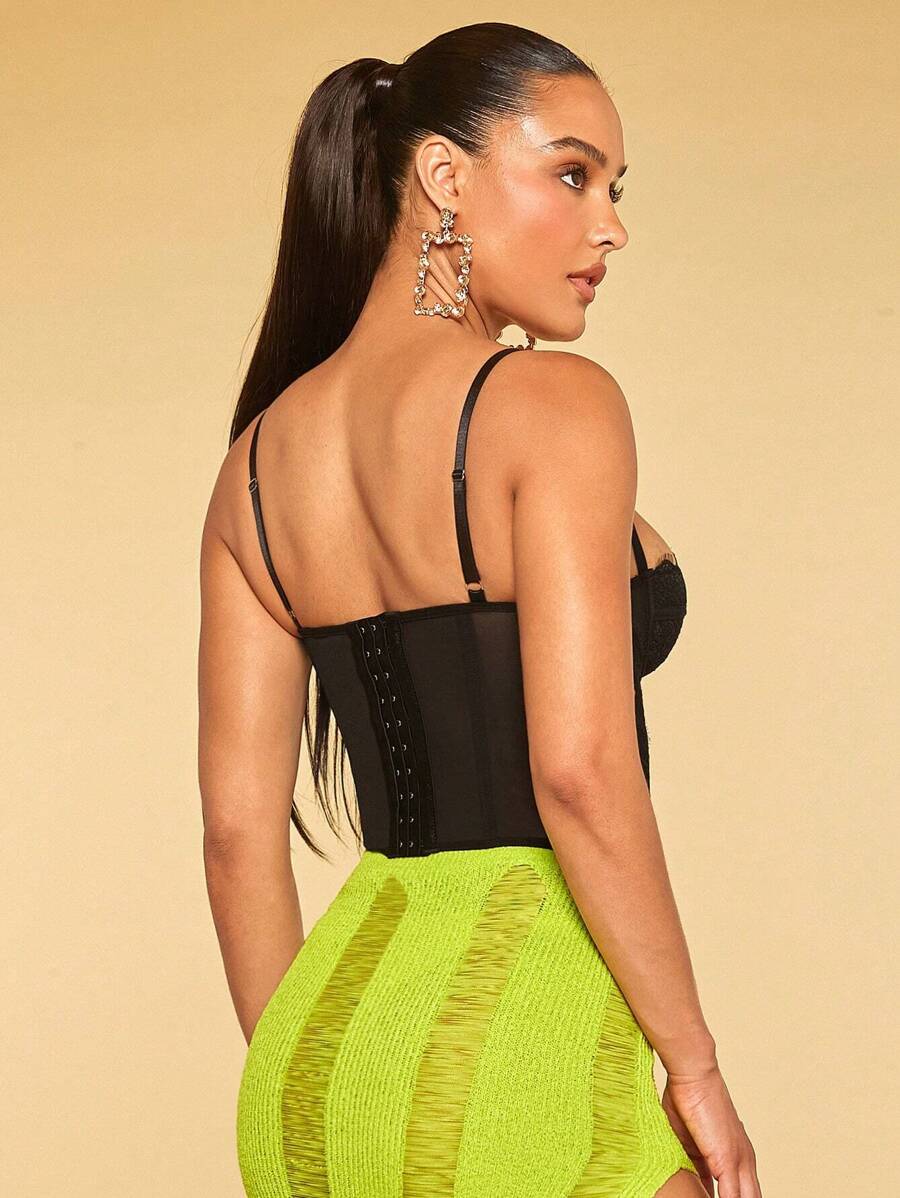 Vista frontal de corset negro ajustado con encaje y tirantes finos.