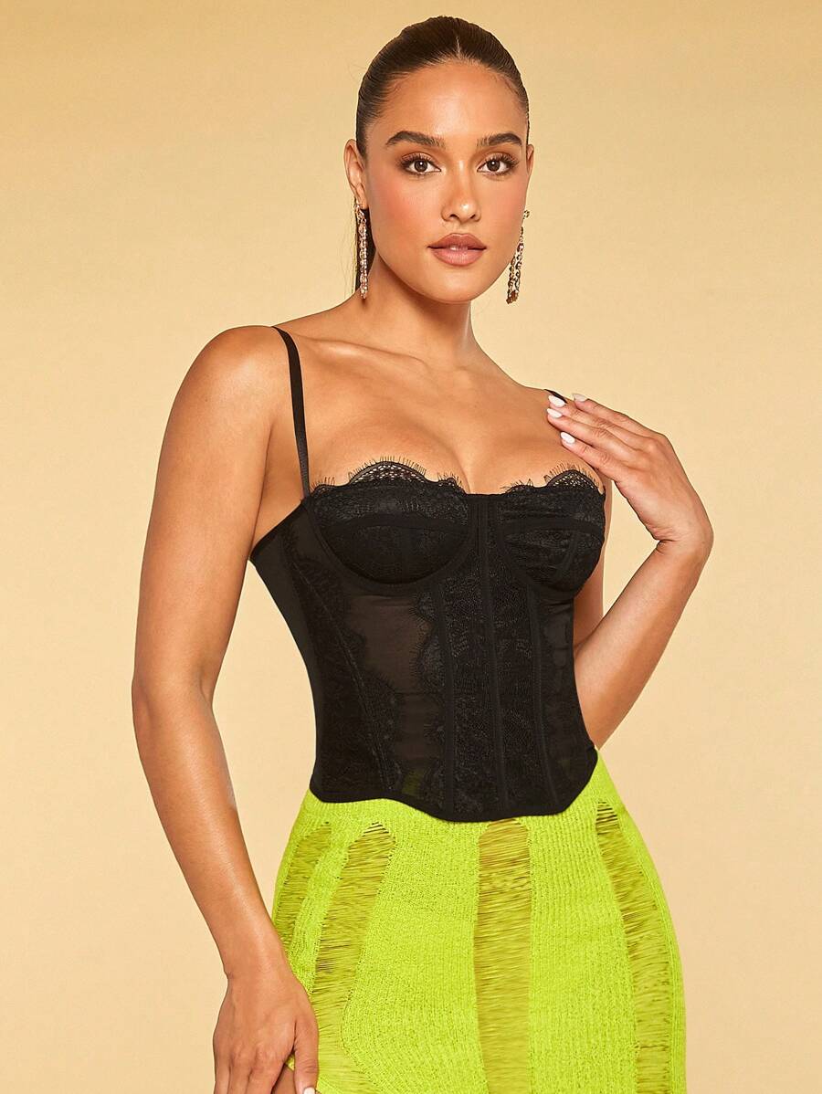 Vista frontal de corset negro ajustado con encaje y tirantes finos.