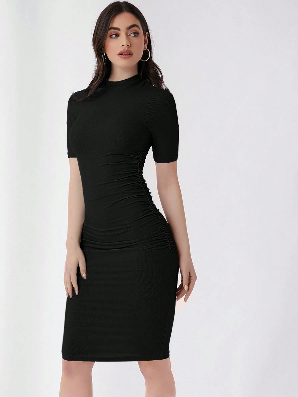 Mujer luciendo vestido negro ajustado con cuello alzado y corte lápiz.