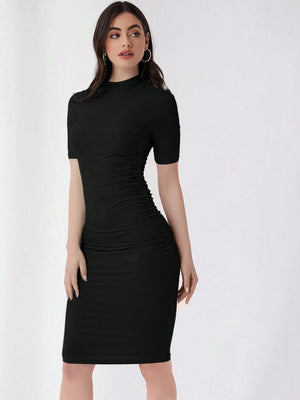 Mujer luciendo vestido negro ajustado con cuello alzado y corte lápiz.