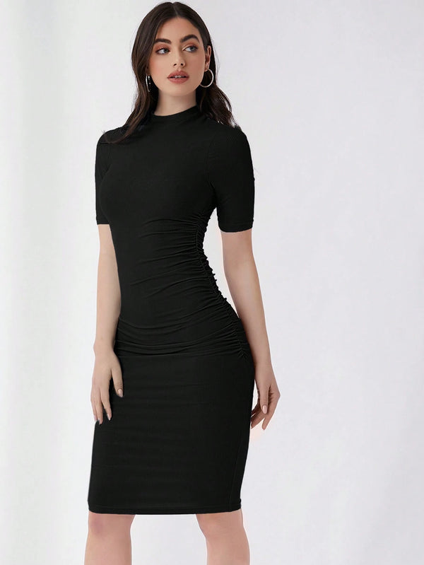 Mujer luciendo vestido negro ajustado con cuello alzado y corte lápiz.