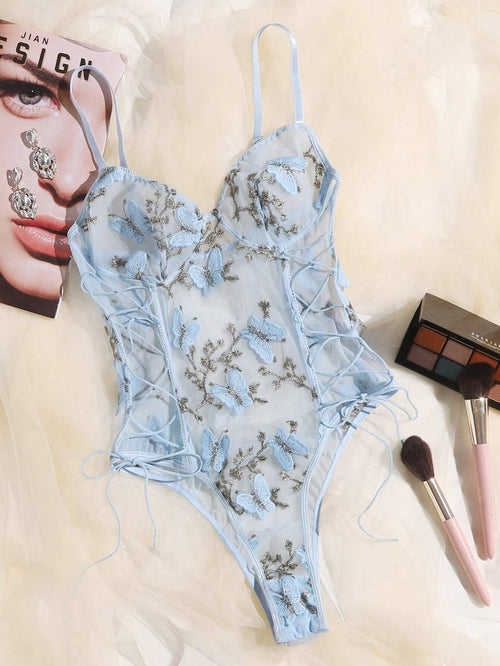 Vista frontal del body celeste romántico-floral bordado con transparencias y lazos laterales.
