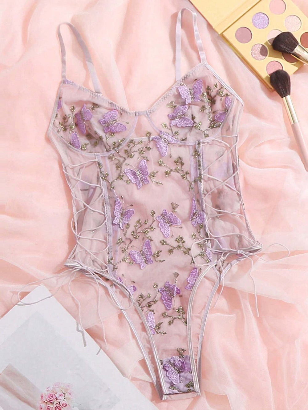 Body romántico floral en púrpura malva con bordado de mariposas.