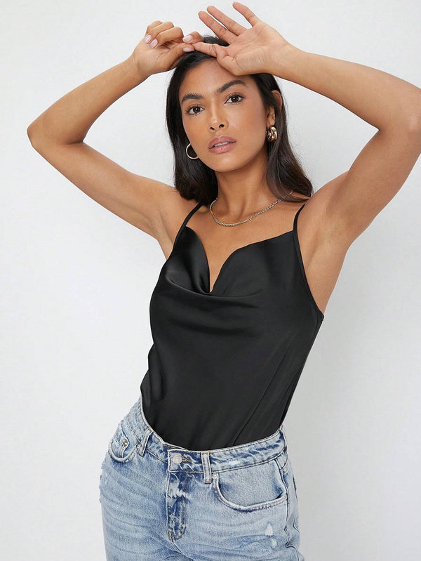 Detalle del escote drapeado de la blusa negra.